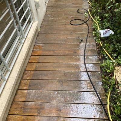 דק עץ רטוב עם צינור מים וגינה