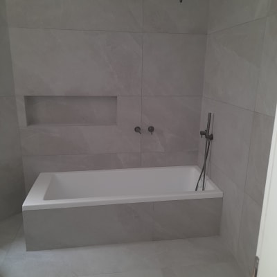 אמבטיה חדשה עם אריחים אפורים וברז שחור