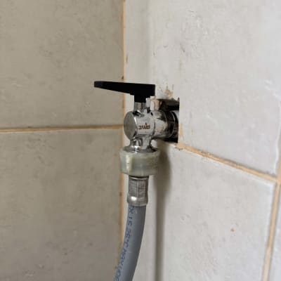 ברז מים עם צינור גומי מחובר לקיר