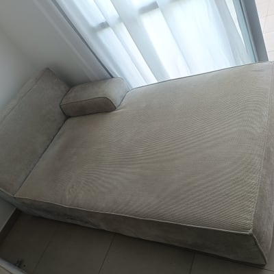 ספה אפורה ליד חלון עם וילון לבן