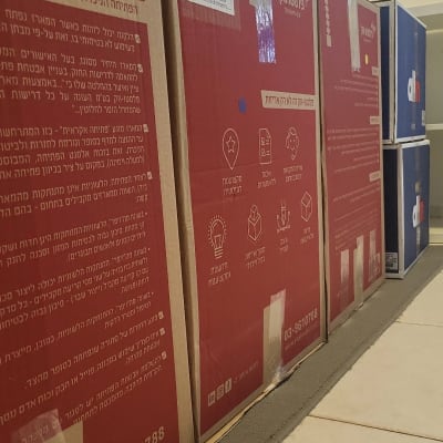 קופסאות קרטון עם כיתוב בעברית על הרצפה