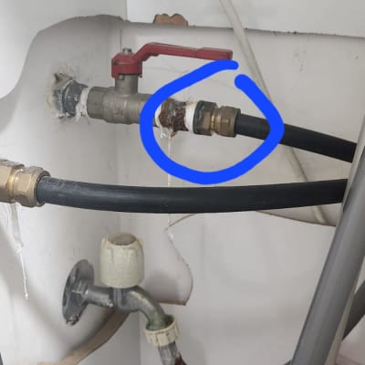 צינור מים עם ברז אדום וחיבורים חלודים