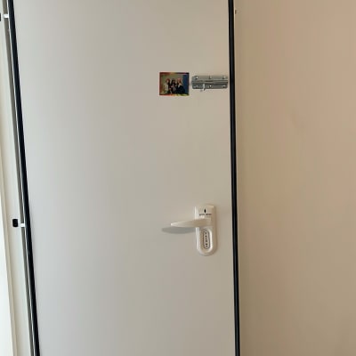 דלת לבנה עם מנעול ובריח מתכת