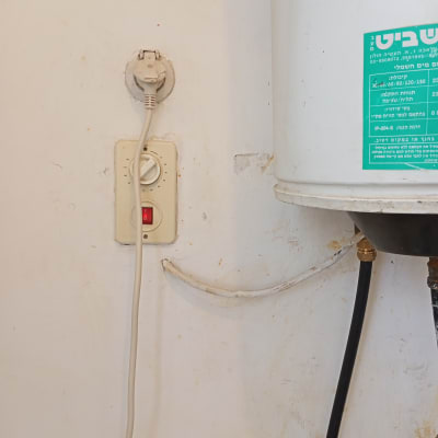 שקע חשמל עם תקע וכבל מחובר לדוד חשמלי