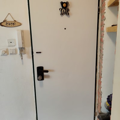 דלת לבנה עם ידית שחורה וקישוט דובי