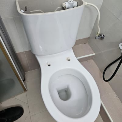 אסלה פתוחה עם מיכל מים בחדר אמבטיה