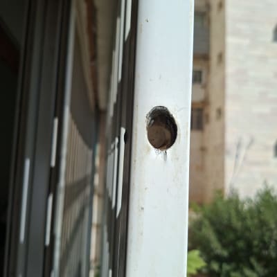 חור בדלת מתכת ליד בניין מגורים