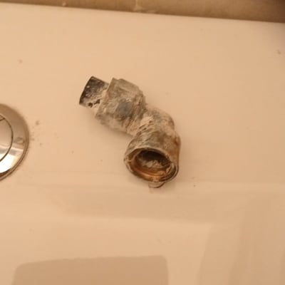 חלק צנרת ישן ומלוכלך על משטח לבן