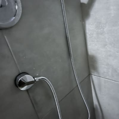 צינור מקלחת מתכת מחובר לקיר