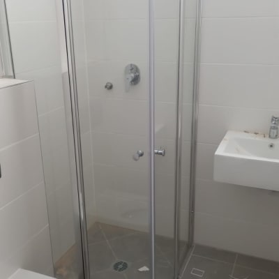 מקלחון זכוכית עם דלתות מתכת וברז מים