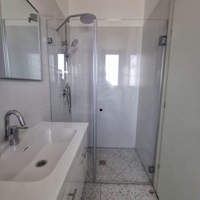 מקלחת עם ראש מקלחת ודלת זכוכית