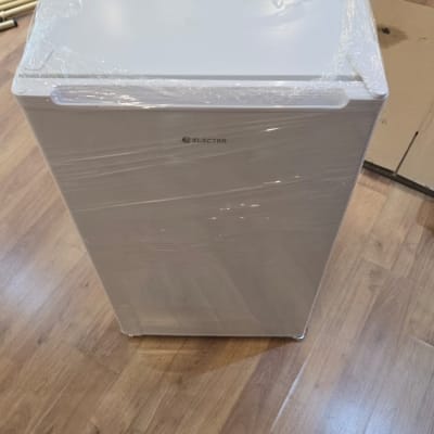 מקרר עטוף בניילון על רצפת עץ