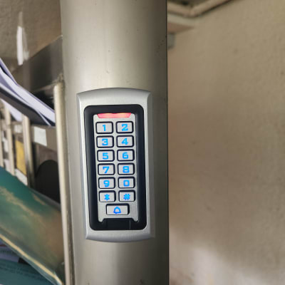 לוח מקשים עם תאורה כחולה על עמוד מתכת