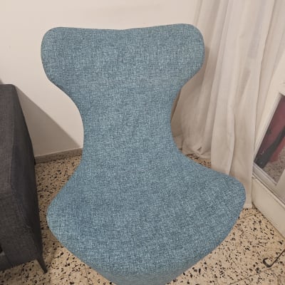 כיסא מרופד בבד כחול על רצפת אריחים