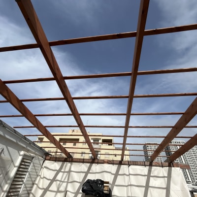 מבנה עץ פתוח עם קורות עץ בשמיים כחולים