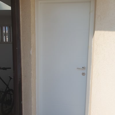 דלת לבנה עם ידית מתכת כסופה