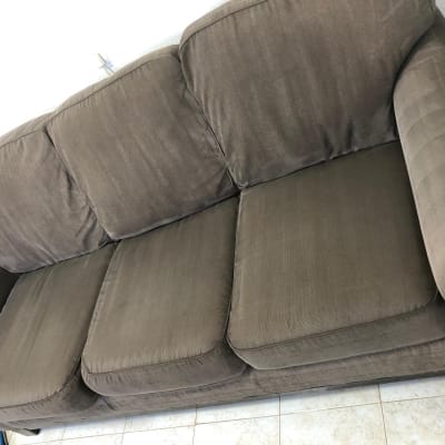 ספה חומה עם שלושה מושבים על רצפת אריחים