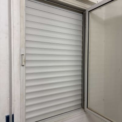 תריסים לבנים סגורים במסגרת חלון לבנה