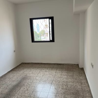 חדר ריק עם קירות צבועים ורצפת אריחים