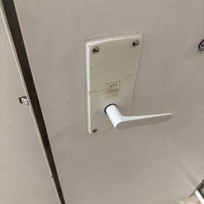 ידית דלת לבנה עם כיתוב דלת אוטומטית