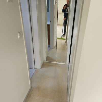 אדם מנקה מסדרון עם מגב