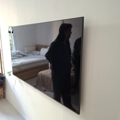 טלוויזיה מותקנת על קיר בחדר שינה