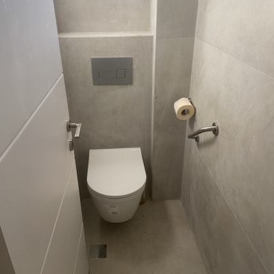 שירותים חדשים עם קיר אריחים ולחצן הדחה