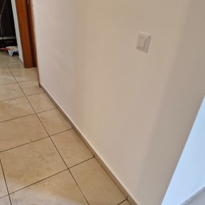 קיר צבוע עם מתג חשמל ורצפת אריחים