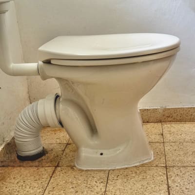 אסלה עם צינור גמיש מחובר לקיר