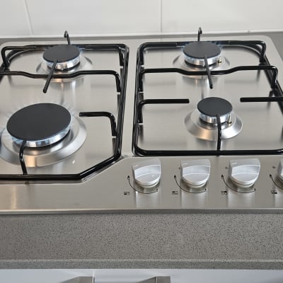 כיריים גז עם ארבעה מבערים וכפתורי שליטה