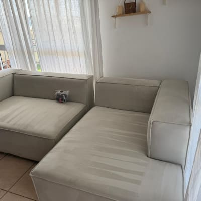 ספה נקייה ליד חלון עם וילונות לבנים