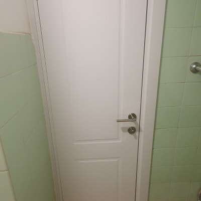 דלת לבנה עם ידית מתכת בחדר אמבטיה