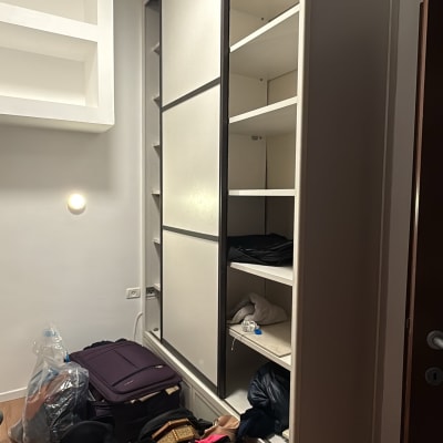 ארון בגדים פתוח עם מזוודות ובגדים על הרצפה
