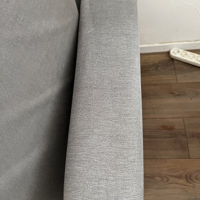 ספה אפורה עם משענת יד על רצפת עץ