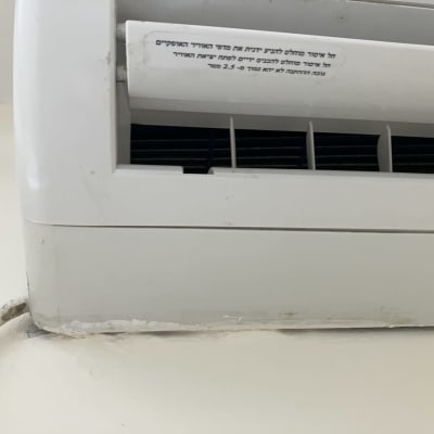 מזגן עם מדבקה בעברית על פתחי האוורור