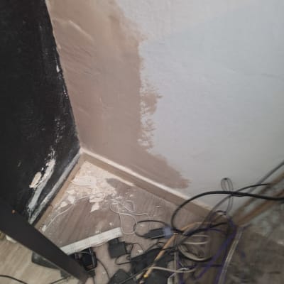 קיר צבוע חלקית עם סימני צבע שונים