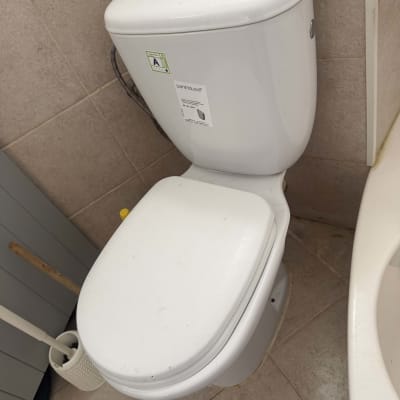 אסלה עומדת עם ניאגרה גלויה מחרס מותקנת בחדר רחצה