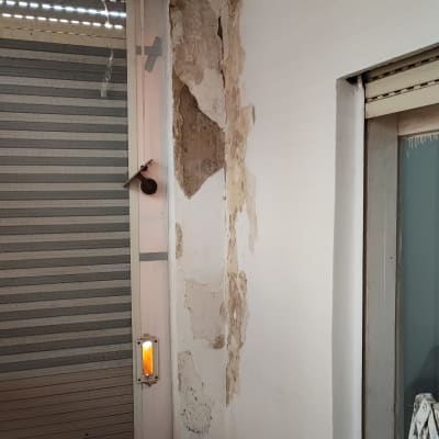 קיר עם קילופי צבע ותיקונים ליד חלון