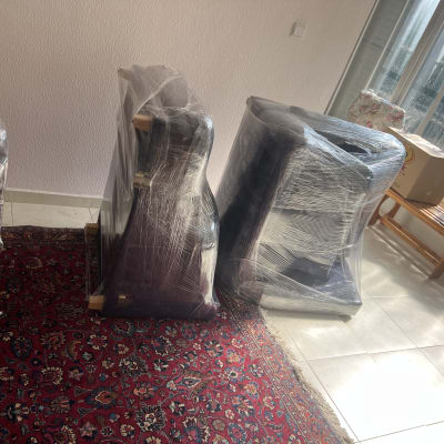 רהיטים עטופים בניילון בחדר מואר עם שטיח אדום