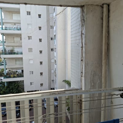 מרפסת עם רשת בטיחות ומבנים ברקע