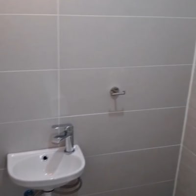 כיור קטן בחדר אמבטיה עם קיר אריחים
