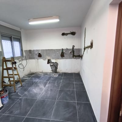 חדר בשיפוץ עם קיר פתוח, סולם ודלי צבע