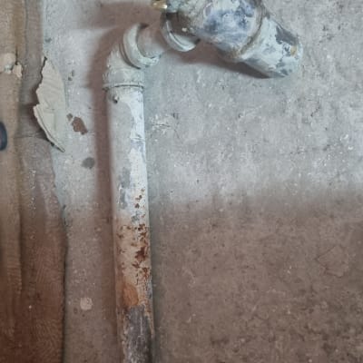 צינור חלוד על רצפה עם חיבורי מתכת