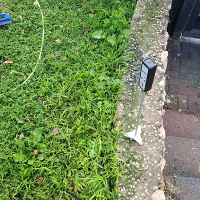 מכשיר איתור נזילות על דשא ליד מדרכה