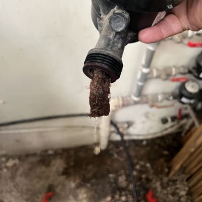 יד מחזיקה צינור עם סתימה של לכלוך