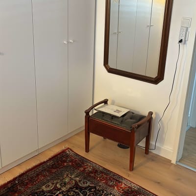 שטיח צבעוני, מראה על קיר, כיסא עם כרית