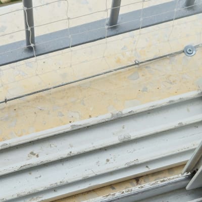 רשת מתוחה על מעקה למניעת כניסת יונים