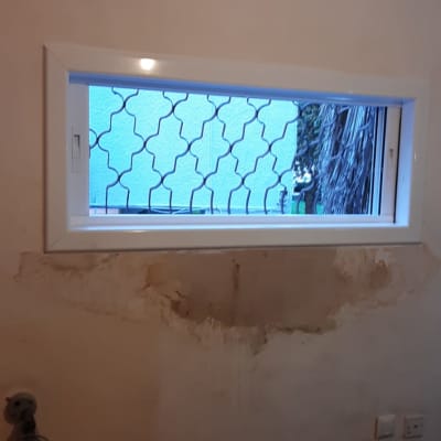 חלון עם מסגרת אלומיניום וקיר מתקלף