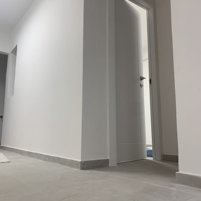 קיר לבן ודלת פתוחה בחלל משופץ