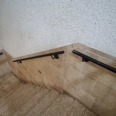 מעקה מתכת שחור לאורך גרם מדרגות פנימי